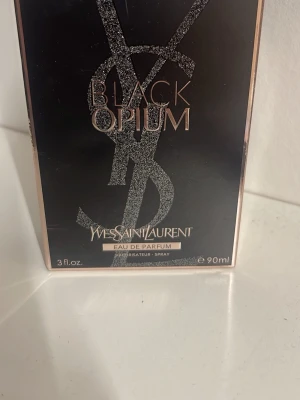 Yves Saint Laurent Black Opium EdP 90ml - Yves Saint Laurent Black Opium Eau de Parfum i en snygg svart och roséguldig förpackning. Flaskan rymmer 90 ml och doften är känd för sina intensiva och sensuella toner. Perfekt för dig som gillar lyxiga och moderna parfymer.