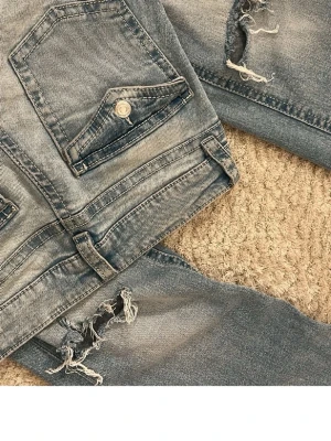 Blå slitna jeans med hål - Säljer ett par blå jeans med slitningar från Gina tricot💕
