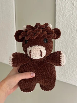 Brun virkad ko  - Virkat gosedjur i velvetgarn. Kon är 26cm lång och tillverkad för hand, vilket gör varje ko unik. Kon har svarta säkerhetsögon som sitter fast från insidan. Rekommenderas dock inte för de allra minsta barnen, då det alltid finns en viss risk, vid hårt drag, att de lossnar. Perfekt som present eller mysig inredningsdetalj! Tvättråd: max 30°C, handtvätt.