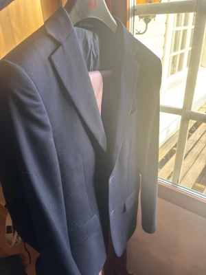 Mörkblå kavaj - Snygg mörkblå kavaj med smal passform från dressman. Perfekt för en stilren look. Modell slim fit (short) storlek 44, bara använd 1 gång, pris kan diskuteras, slips ingår vid snabb affär