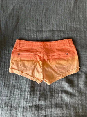 Lågmidjade jeansshorts - Jätte jätte snygga lågmidjade jeansshorts, färgen är inte alls så orange som den ser ut som, det är mycket mer rosa i verkligheten. Mer som den näst sista bilden. Materialet är jätte skönt och snygga shorts inför sommaren!