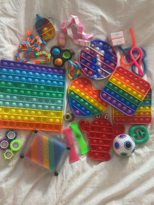 Stort paket med fidgetleksaker - Säljer ett mixat paket med fidgetleksaker i olika former och färger, bland annat regnbågsfärgade pop it i hjärta, cirkel, fyrkant och krabba, stressbollar, kuber, snurror och stretchy leksaker. Materialet är mestadels silikon och plast. Perfekt för dig som gillar att pilla och hålla händerna sysselsatta.Går att köpa alla eller styckvis såklart  💕