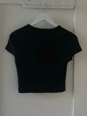 Svart T-shirt  - Svart t-shirt i ribbat material, storlek M. Hel och fin. Den är liten i storlek dock så passar S 