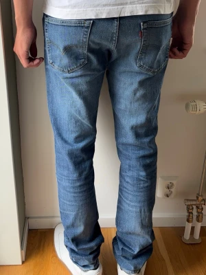 Levis 511 Jeans Vintage - Levis 511. Raka jeans.  Färg: Blå med lätta fades | Modell: 511 | Storlek: W34 L34 | Vintage Premium Jeans. Passar perfekt på killen i bilden som är 189 cm.  Lite slitna i grenen men inget som påverkas vid användning.   Mått: Midja: 43 cm Längd: 108 cm Beslut: 18 cm Lår från grenen: 27 cm  Tveka inte att höra av dig minsta fråga eller fundering!  Skickas snabbt!