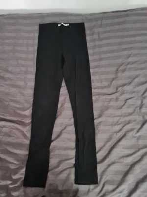Svarta leggings från 157 - Svarta, klassiska leggings från 157 med hög midja och smal passform. Tillverkade i ett stretchigt material som sitter skönt mot kroppen. Perfekta att matcha med oversized tröjor eller hoodies.