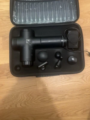  Dakota Svart massagepistol med tillbehör - Massagepistol i svart med flera utbytbara massagehuvuden och laddare, allt i en praktisk förvaringsväska. Ergonomiskt handtag och LED-indikatorer för batterinivå. Perfekt för muskelavslappning och återhämtning.