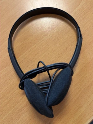 Svarta on-ear hörlurar med sladd - Säljer ett par klassiska svarta on-ear hörlurar med mjuka öronkuddar i tyg och justerbart huvudband. Hörlurarna har en sladd med 3,5 mm kontakt, perfekt för dator eller mobil. Enkla och smidiga att ta med sig överallt.