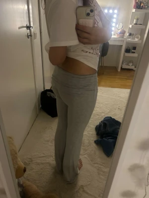 Grå mjukisbyxor med utsvängda ben - Säljer ett par grå mjukisbyxor med utsvängda ben och bred resår i midjan. Byxorna är i ett mjukt och stretchigt material som känns riktigt sköna. Perfekta för chill dagar hemma eller när du vill ha något bekvämt på dig.