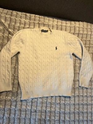 Ralph lauren tröja  - En vit Ralph lauren kabelstickad sweatshirt. Den är bra men använt skick. Passar Xs eller en större barn Stolek. 