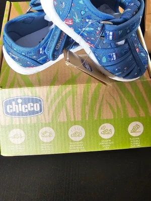 Blå sandaler med bilar från Chicco - Säljer ett par blå sandaler från Chicco med coolt bil- och trafikmönster. Sandalerna har kardborreband för enkel påtagning och vit sula. Tillverkade i textilmaterial som andas och är lätta och flexibla. Perfekta för sommaren! Storlek 22 (motsvarar runt 13,5cm) 