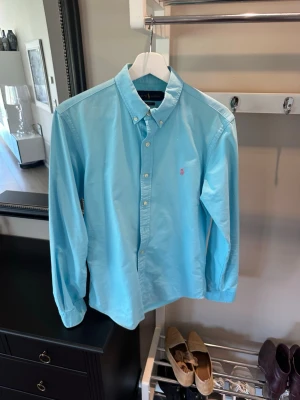 Ljusblå skjorta från Ralph Lauren - ljusblå skjorta från Ralph Lauren och rosa logga på bröstet. Har du small, ish medium passar den riktigt gött