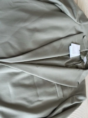 Beige oversized kavaj från reiss  - Stilren beige kavaj från reiss med klassisk passform och breda slag. Kavajen har två framfickor med lock och en bröstficka. Perfekt för en trendig och avslappnad look. Materialet är slätt och ger en snygg finish.