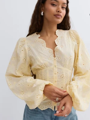 Gul broderad blus med puffärm - Söt gul blus med broderade blommor och vågig kant längs ringningen. Blusen har puffiga långärmar och knäppning framtill. Tillverkad i ett lätt, luftigt tyg som ger en romantisk känsla.ELLER BYT MOT EN 34