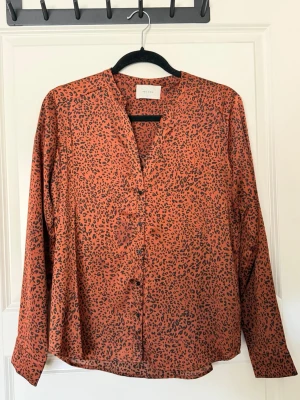 Leopardmönstrad blus! - Elegant blus med leopardmönster från Neo Noir. Blusen har en avslappnad och stilren passform med knäppning framtill och långa armar med fina detaljer vid muddarna. Passar att bäras både till vardags och fest! 🐆