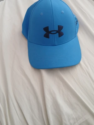 Blå Under Armour keps - Under armour keps. Träning och golf keps. Priset kan diskuseras.
