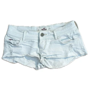 Vita denimshorts från Hollister - Supersnygga denimshorts från Hollister med råa kanter och slitna detaljer. Lågmidjade. W24, 36cm tvärs över. Skriv om du undrar nått, kolla min profil för annat fint!!