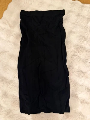 Svart långkjol från Lager 157 - Säljer en svart långkjol från Lager 157  i storlek M. Kjolen har en enkel och stilren design med rak passform och hög midja. Perfekt att matcha med en crop top eller stickad tröja för en snygg look.