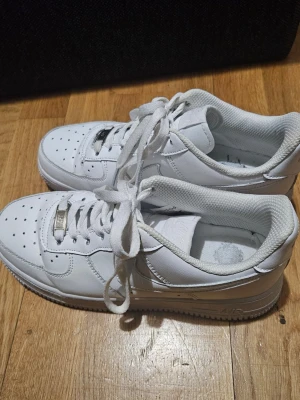 Nike Air Force 1 vita sneakers - Säljer ett par klassiska helvita Nike Air Force 1 i storlek 39. De köptes förra året men säljs nu då de tyvärr är för stora för mig.  Skorna är endast använda 1–2 gånger och är i princip som nya. 