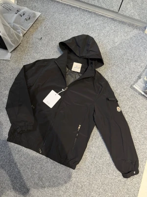 Moncler black windbreaker - Size M, fits 100% true to size. Just like new, never worn. Feel free to ask questions. Yes we ship to sweden and other countries too.