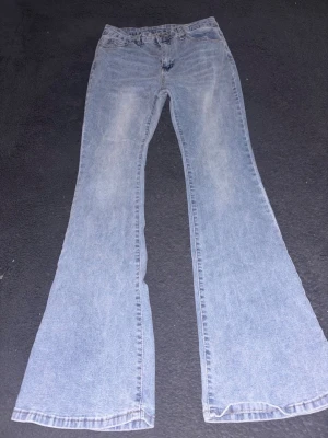 Ljusblå utsvängda jeans bootcut - Säljer ett par ljusblå jeans med bootcut och utsvängda ben. Klassisk femficksmodell med normalhög midja och dragkedja. Perfekta för dig som gillar retrostil och vill ha ett par bekväma jeans i bomull.