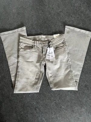 Ultra low bootcut jeans  - Gråa Lågmidjade jeans ifrån Ginatricot i storlek 38 💞  helt oanvända med alla lappar kvar då jag råkade beställa fel storlek men glömde att skicka tillbaka 💞modellen är ultra low bootcut jeans och färgen heter Lt grey 🩶hör av er om ni har några mer frågor eller vill ha fler bilder 💞