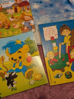 Färgglada barnpussel med motiv - Säljer flera barnpussel med motiv av Bamse, bondgård, Mumin och lekande barn. Pusselbitarna är stora och gjorda i trä och kartong, perfekta för yngre barn. Fina färger och tydliga illustrationer gör dem roliga att lägga.