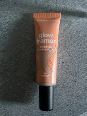 Max Factor Glow Framer Bronzer 20 Honey - Max Factor Glow Framer bronzing & illuminating tint i färgen 20 Honey. Kommer i en smidig tub med svart skruvkork. Ger en varm, gyllene ton och glow till huden. Perfekt för att framhäva ansiktets konturer och skapa en solkysst look. Aldrig använd😇