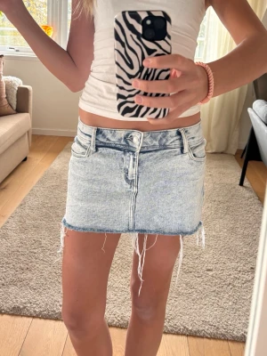Lågmidjad jeanskjol - Super snygg Lågmidjad jeanskjol med fransar. Aldrig använd. Stretch material