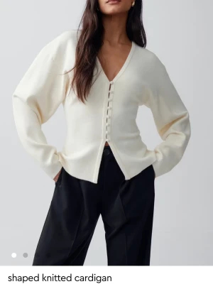 shaped knitted cardigan - I storlek L men känns mer som en stor S/ liten M. Snygg krämvit kofta från Ginatrico med V-ringning och dekorativa knappar framtill. Koftan är stickad i mjukt material och har långa ärmar. Perfekt att slänga över en topp för en chill look men kan även kläs upp för en festligare look