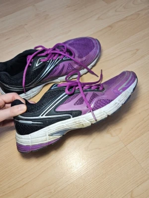 Lila och svarta sneakers från BLWR storlek 40 - Storlek 40. Snygga sneakers från BLWR i lila och svart med vita detaljer och snörning. Skorna har en sportig design med meshpartier för bra ventilation och en rejäl vit sula som ger bra stöd. Perfekta för dig som gillar färg och vill sticka ut. Använt skick inga skavanker men lite smutsiga i sulan. 