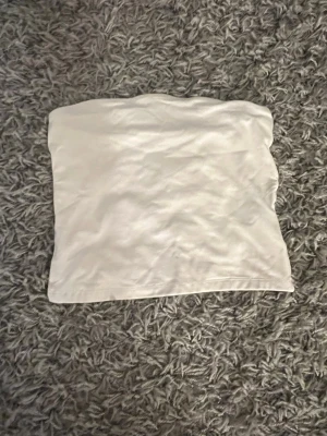 Vit tubtopp - Enkel och stilren vit bandeau tubtopp i mjukt material. Från bershka i strl M. Skriv om ni undrar något pris kan diskuteras💕