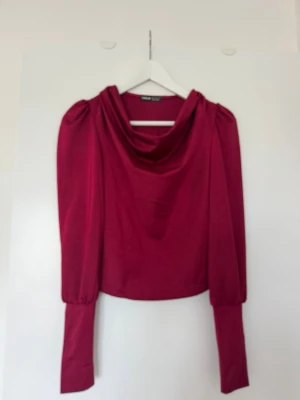 Vinröd långärmad topp  - Trendig vinröd topp från Shein med långa ärmar och snygg draperad halsringning. Toppen har en croppad passform och är tillverkad i ett mjukt material som känns skönt mot huden. Perfekt för dig som vill sticka ut med färg och stil.