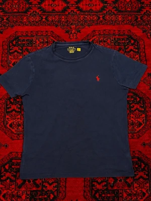 Mörkblå t-shirt från Polo Ralph Lauren - Storlek M, men passar bättre på S för en normal fit fungerar även för M beroende på önskad passform. Längd: 65 cm Bredd: 48 cm  Skick: 8/10. Tvättas och fräschas upp innan frakt ✨ Pris kan diskuteras vid snabb affär eller bundle köp!
