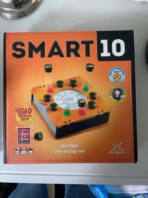 Smart10 frågespel orange Mindtwister - Smart10 är ett frågespel i orange och svart plast där alla får svara på samma fråga. Spelet innehåller 200 frågor och 2000 möjliga svar. För 2-8 spelare, passar perfekt för spelkvällar med vänner eller familj.