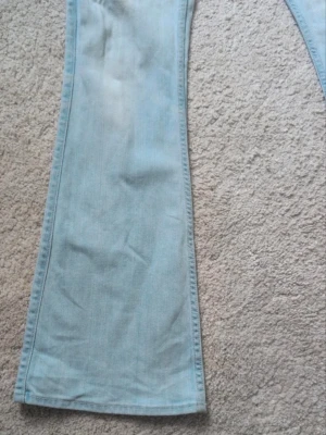 Ljusblå bootcut jeans från Bondelid - Säljer ett par ljusblå bootcut jeans från Bondelid. Jeansen har klassisk femficksmodell, normal midja och utsvängda ben. Tillverkade i mjukt denimtyg som ger en avslappnad och trendig look. Perfekta för dig som gillar retrovibbar och vill sticka ut.