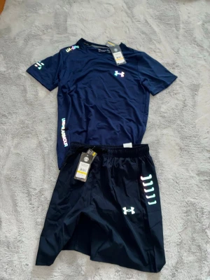 Under Armour träningsset marinblå - Snyggt träningsset från Under Armour i marinblått, består av en t-shirt och shorts. 