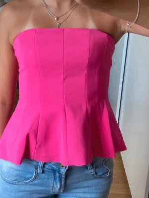 Rosa axelbandslös korsettopp - Snygg rosa korsettopp med axelbandslös design och figurnära passform. Helt ny, perfekt färg och passform till sommaren
