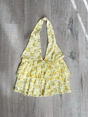 Gul topp - Gul blommig topp storlek S. Köpt från Gina tricot. Endast använd en gång 