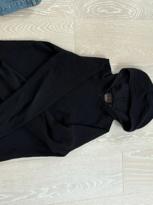 Svart hoodie från Oscar Jacobson - En stickad kashmir hoodie från Oscar Jacobson med klassisk huva och lång ärm. Hoodien har en rak passform och är gjord av kashmir. Perfekt för en avslappnad och stilren look.