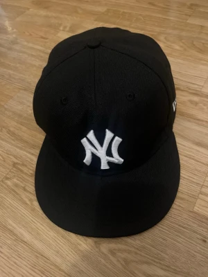 Svart New Era Yankees keps - Säljer en svart New Era 59FIFTY keps med klassiskt New York Yankees broderat vitt logotyp framtill. Kepsen ar helt ny. Storlek 7 1/8 Storlek: 56,8 cm