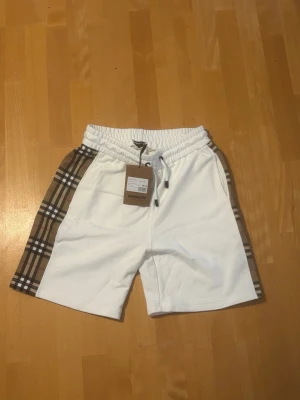 Vita Burberry shorts med rutiga sidor - Snygga vita shorts från Burberry i stl S helt nya och aldrig använda.