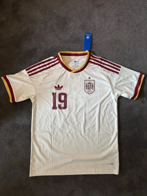 Spanien VM 26/27 borta Lamine Yamal 19 - Fotbollströja med Lamine Yamal på ryggen. Tröjan är helt ny med tagg kvar och i perfekt skick. Perfekt för dig som är supporter, samlar på fotbollströjor eller vill ha en snygg tröja till träning och vardag.                                                                      ⚪ Skickas inom 24 timmar.                                         Vid intresse eller frågor är det bara att skicka 👍