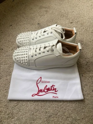 Loubs skor - Vita skor med nitar, säljer då de va för stora och priset beror på att jag ej har något kvitto. Man får med extra nitar och allt som visas på sista bilden.