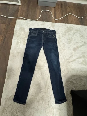 Mörkblå skinny jeans från Replay - Snygga mörkblå skinny jeans med klassisk femficksdesign och kontrastsömmar. Jeansen har normal midja och smal passform hela vägen ner. Tillverkade i stretchigt denimtyg för extra komfort och rörelsefrihet.