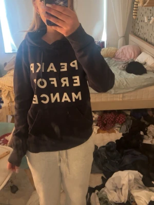 Svart hoodie från Peak Performance - Säljer en svart hoodie från Peak Performance med stor vit text på framsidan. Hoodien har huva med dragsko och är gjord i mjukt, fleecefodrat material som är riktigt skönt. Perfekt för dig som gillar en avslappnad och sportig stil. Aldrig andvänt.