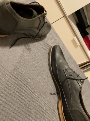 Svarta loafers från Crispanti - Säljer ett par svarta loafers från Crispanti i äkta läder. Skorna har klassisk design med snörning och kontrastfärgad sula i brunt. Perfekta för dig som gillar stilrena och tidlösa skor med en modern touch.