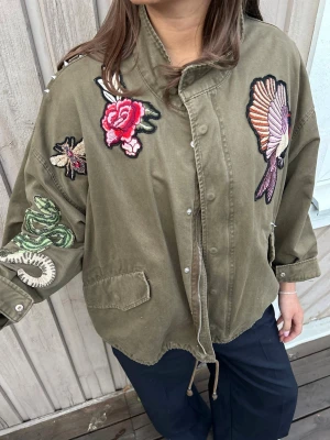 Populära gröna jackan från HM med fåglar/blommor/detaljer! - Säljer den superfina olivgröna jackan från HM med fin broderier av orm, blomma, fågel och insekt. Jackan har tryckknappar, dragkedja, fickor och nitar på axlarna. Oversized passform och dragsko nedtill för extra stilpoäng💗kan gå ner i pris vid snabb och smidig affär!!