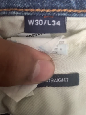Blå raka jeans i klassisk modell Gant  - Säljer ett par blå jeans med rak passform och klassisk femficksdesign. Jeansen har en snygg tvättad look och är tillverkade i denim med lätt stretch. Perfekta till vardags för en avslappnad stil.