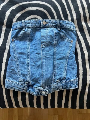 Blå jeans tubtopp - Säljer en snygg blå jeans tubtopp i denim med knappar och dragkedja där bak🥰🥰
