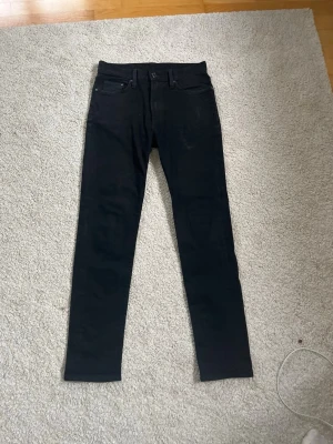 Svarta skinny jeans - Säljer ett par svarta skinny jeans med klassisk femficksdesign och smal passform. Jeansen har normal midja och raka ben. Perfekta till en avslappnad stil och funkar året runt.